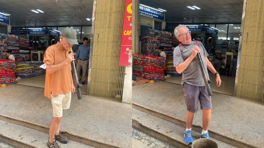 Travelers trying the traditional Vietnamese bamboo smoking pipe during a Hanoi Old Quarter Walking Tour, experiencing local culture and daily life in Hanoi, Vietnam.