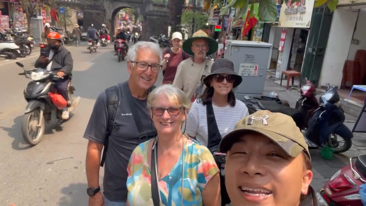 Guests exploring O Quan Chuong gate during a Hanoi walking tour through the Old Quarter with local guide