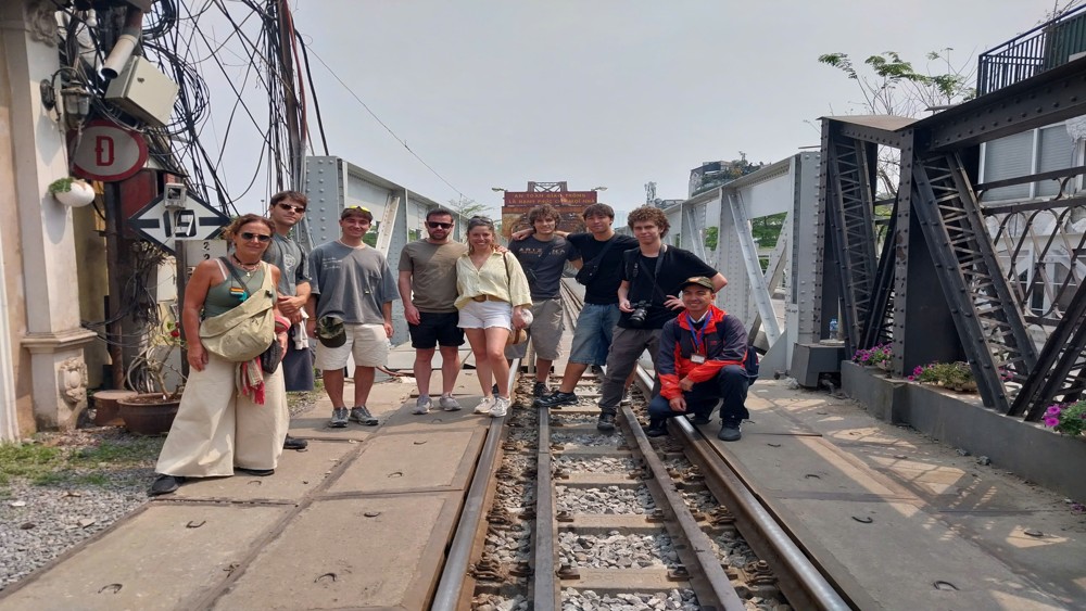 International guests exploring Long Bien Bridge with a local guide during a Hanoi walking tour in the Old Quarter.