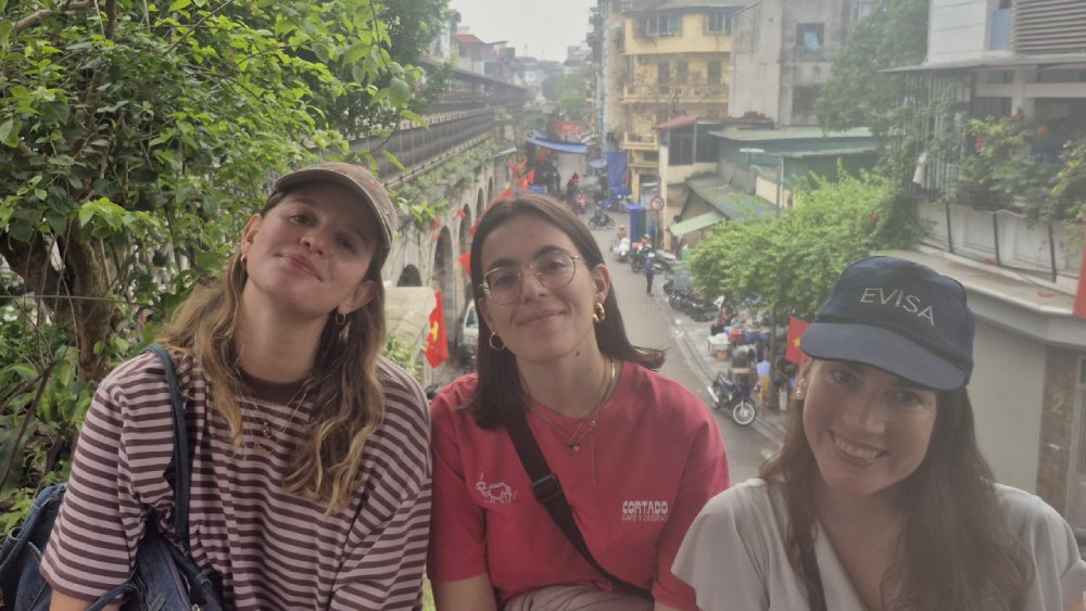 Spanish travelers visiting Hanoi Train Street after a Hanoi Old Quarter Walking Tour, enjoying the unique railway street experience in Hanoi, Vietnam.