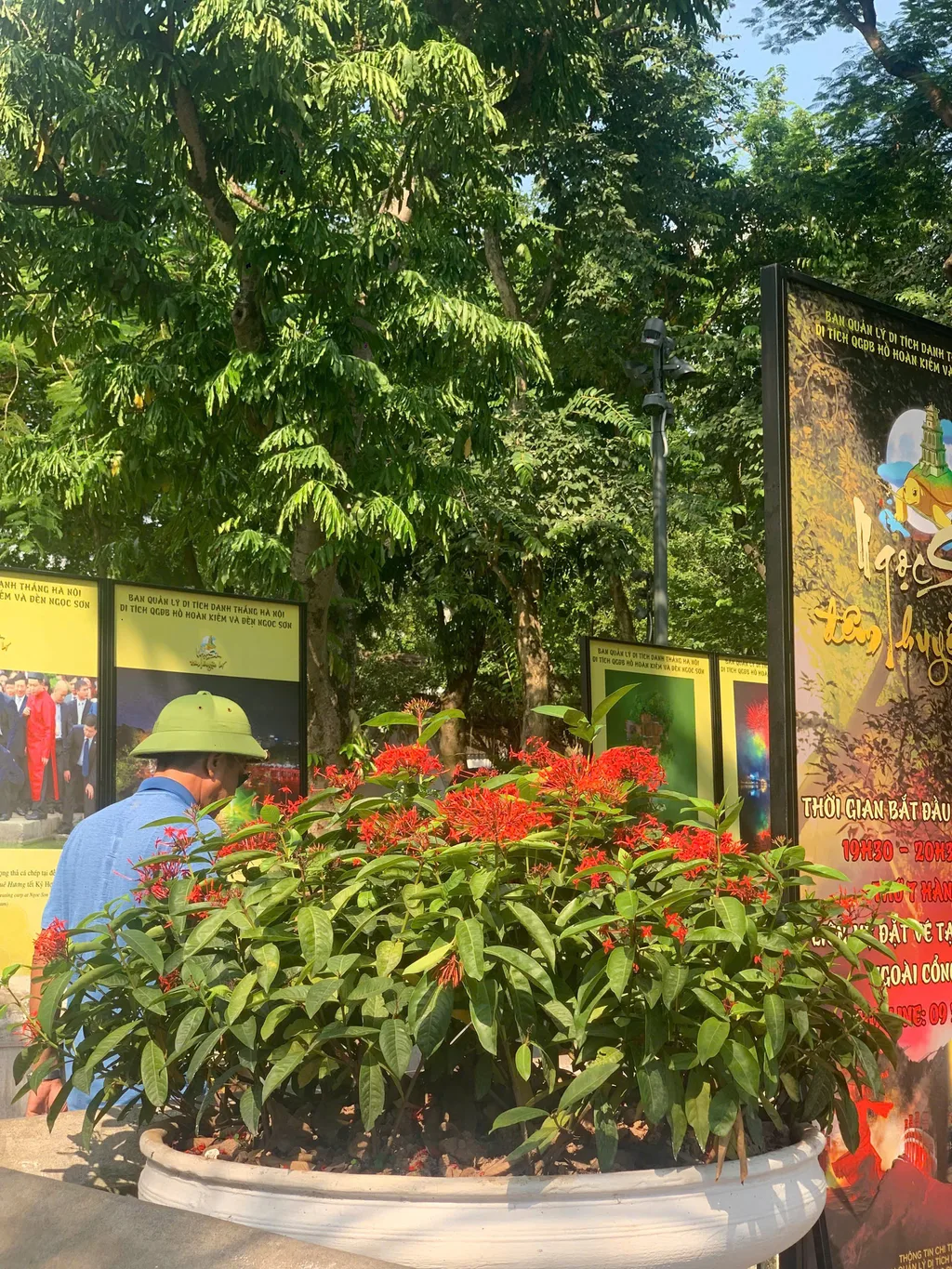 Signage for Ngoc Son Temple by Hoan Kiem Lake with a visitor reading the information boards.