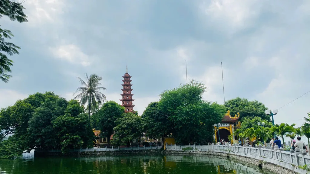Eleven-tier red brick stupa and yellow pagoda gate at Tran Quoc Pagoda on West Lake, Hanoi.