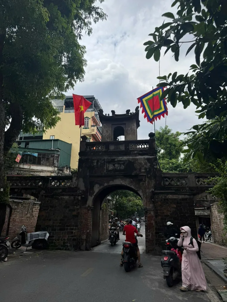 O Quan Chuong gate with motorbike traffic passing through the arch in Hanoi's Old Quarter.