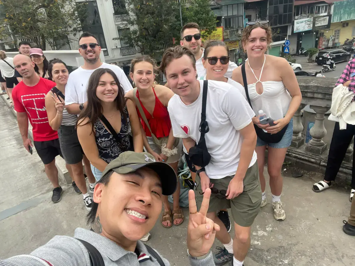 International travellers exploring Hanoi Old Quarter and Long Bien Bridge with local guide Chris during a cultural walking tour.